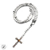 Chapelet pierres fines howlite de 8 mm Orné d'une croix en acier, monté sur un câble d’acier.